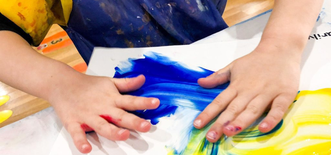 hands smearing paint on paper