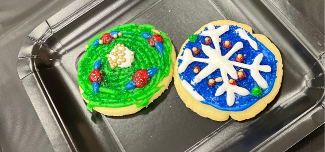 Two decorated cookies on a black plate