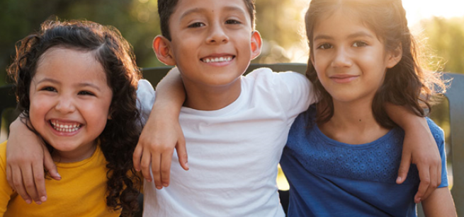 young children girls and boys smiling with arms around each other