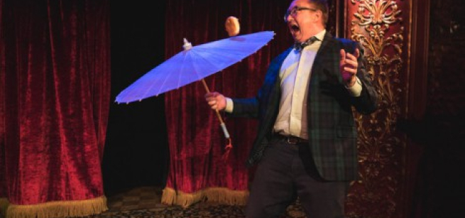 Michael Rayner juggles a cheeseburger on an umbrella