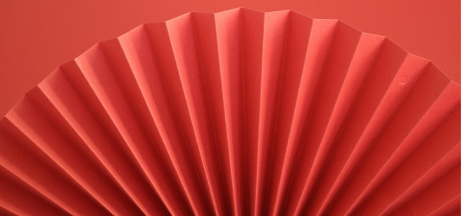A red paper fan on a red background