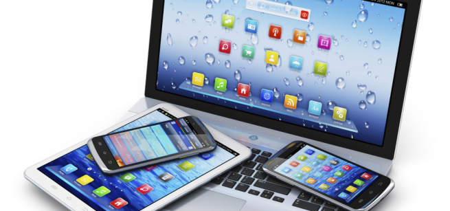 Smart phones and tablet lying on top of a laptop computer.