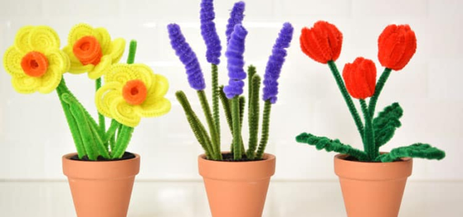 Three flower pots with different flowers made with pipe cleaners. 