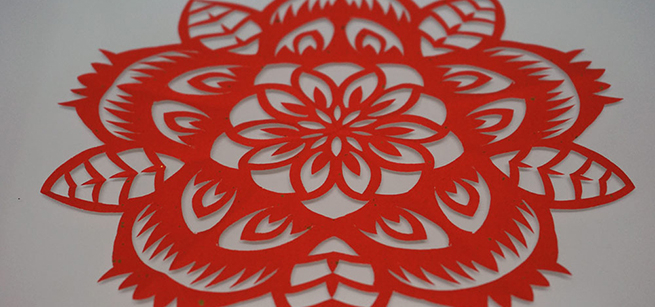 red paper cut into intricate circular design