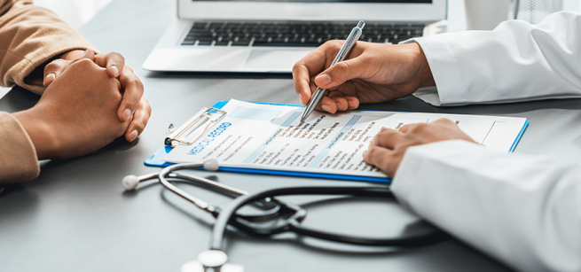 Person in brown sweater sitting and talking to health care professional about their medical record