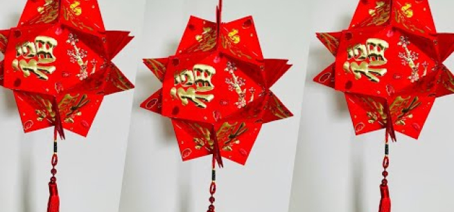 Three red lanterns made of brightly colored red and gold Lunar New Year envelopes are hanging in the image.