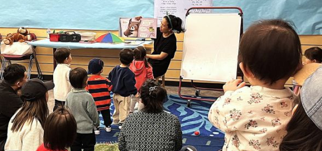 Volunteer reading to a group of kids. 