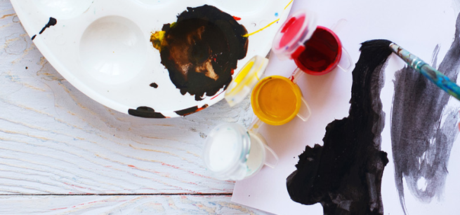 yellow paint, red paint, and white paint on a canvas, palette, and paint brush