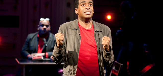 Stew, a young black man is spotlighted on stage 