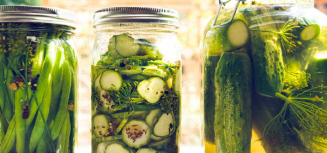 Three jars full with cucumbers and vinegar