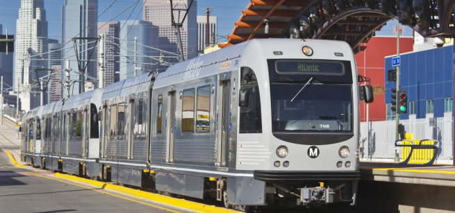 Train on rails with city skyline in the distance