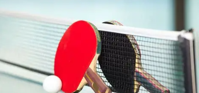 Two table tennis rackets and a ball on a table 