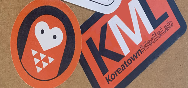 Orange, white and black stickers on a notebook.