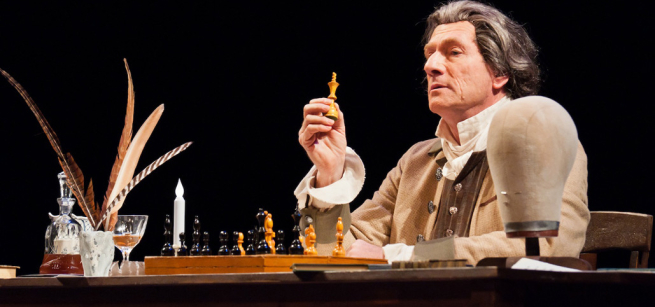 Actor dressed as Thomas Paine holding a chess piece.