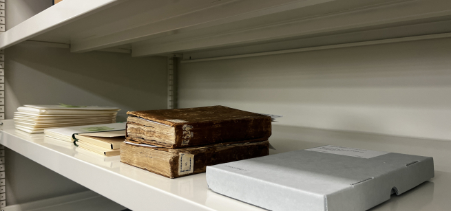 Library shelves with rare books and an example of a clamshell box