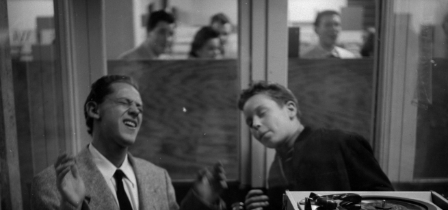 two men singing in a booth