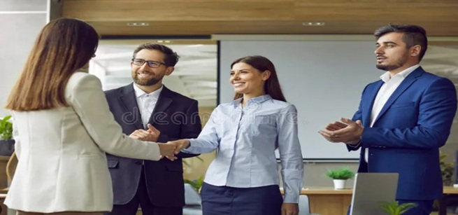 Several people shaking hands and smiling