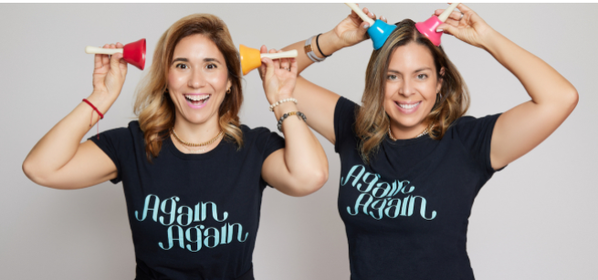 two women holding two hand bells to their head