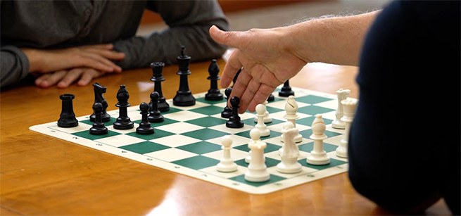 a chess board with two players actively playing a game of chess