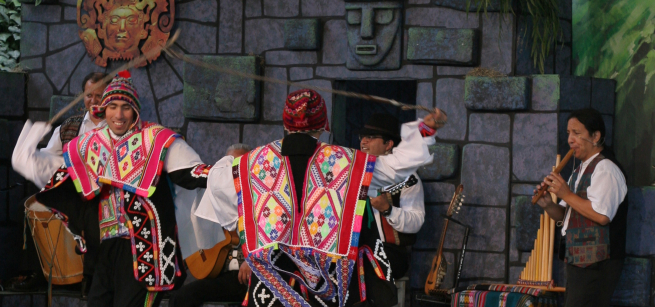 People dressed in Peruvian cultural clothes dancing and playing instruments. 