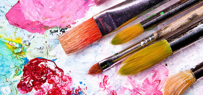 paintbrushes on a palate with mixed paint