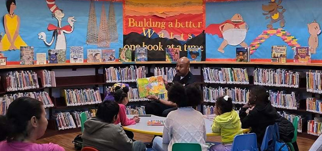 Officer Griffin reading a book to a group of children.