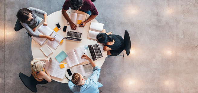 top view of students sitting on a round table studying