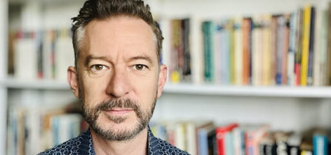 man in front of book shelves