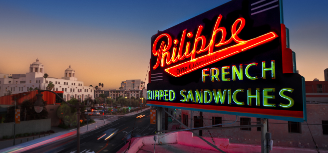 neon Philippes French Dip sign over a sunset