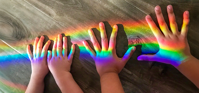 Rainbow and two pairs of hands,