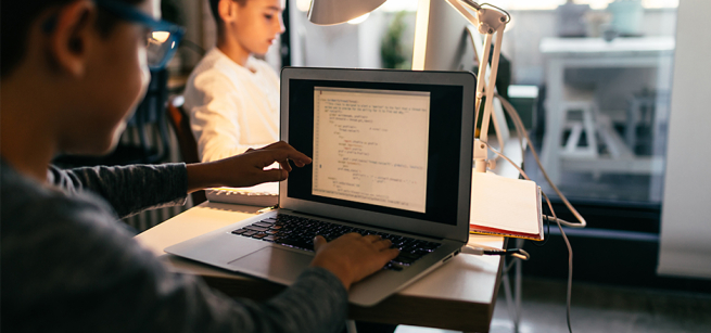 Two children coding on a laptop