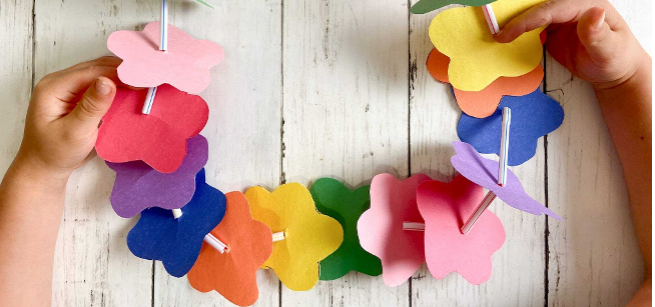 Colorful paper flowers on a string held by child's hands