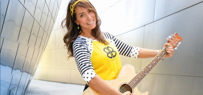 Isabel Brazon, founder of Baila Baila, holds a guitar