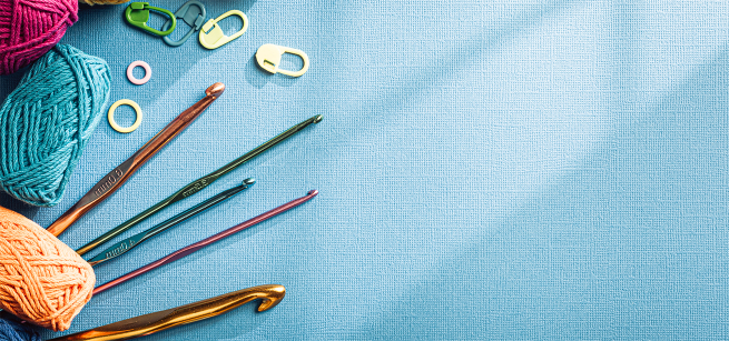 crochet hooks and stitch markers on a blue background