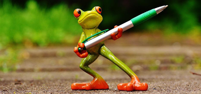 small toy frog holding a pen