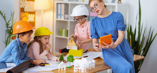 A woman and three children engage in an architecture-theme activity.