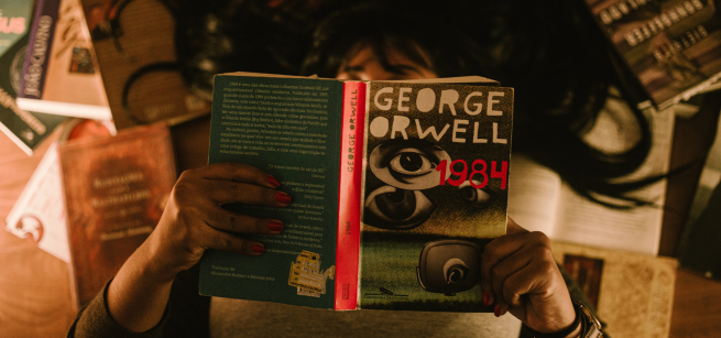 hands holding a book in a dim lit room