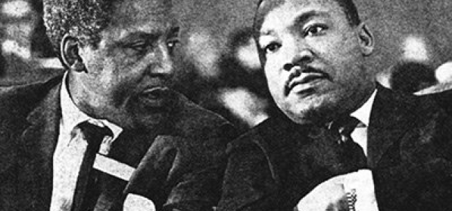 two men in black suits and ties sitting next to each other