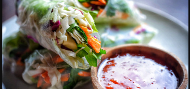 Spring rolls with a container of sauce