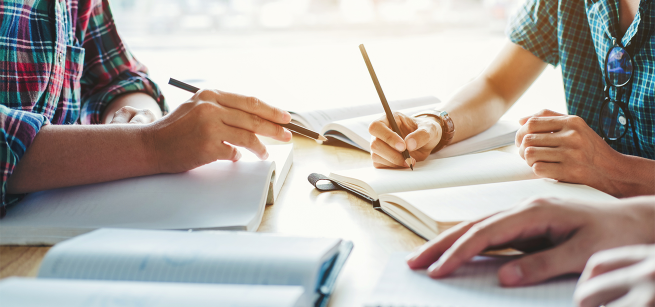 Several people journal together at a table