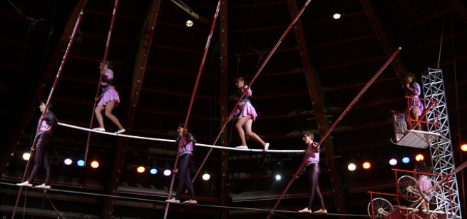A color photo of acrobats on a tightrope