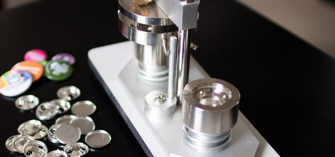 image of a button press next to a pile of unmade buttons