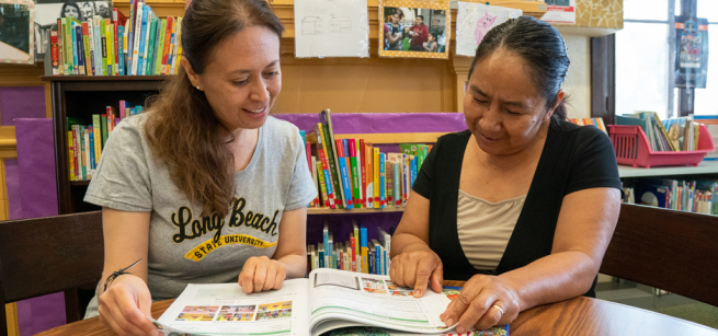 An instructor and a student review a workbook.