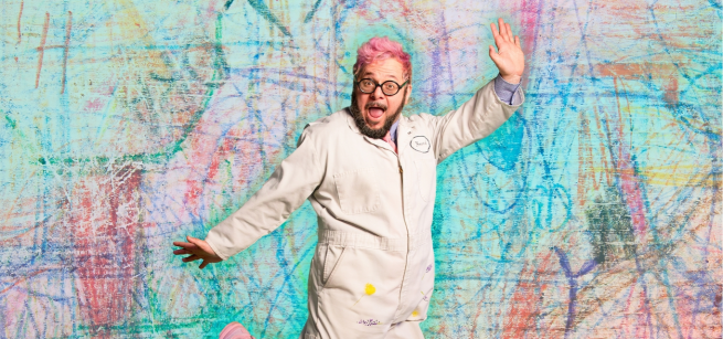ricky rainbow beard - a person with pink hair jumping against a colorful background