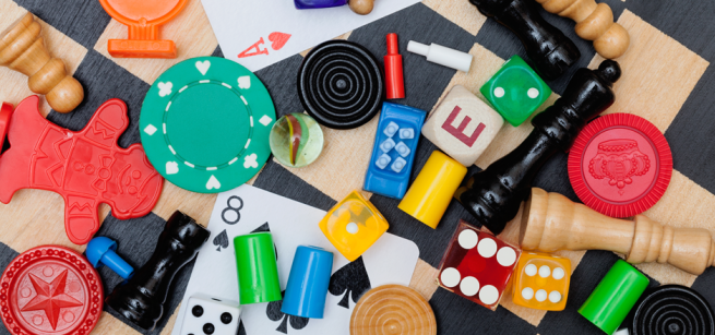 An assortment of game pieces and cards on a checkered board.