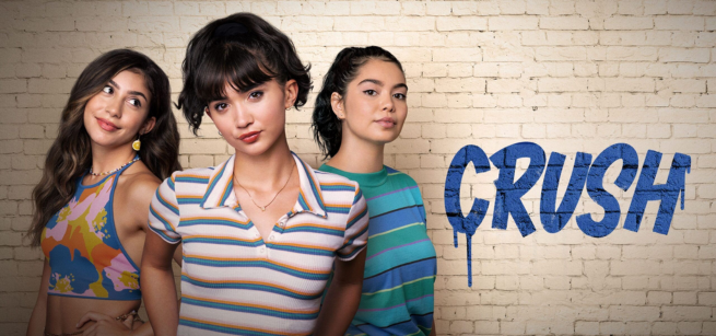 Three young women stand confidently against a white brick wall. The word "CRUSH" is painted in bold, blue letters. 