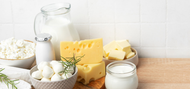 An assortment of dairy products on a wooden counter.