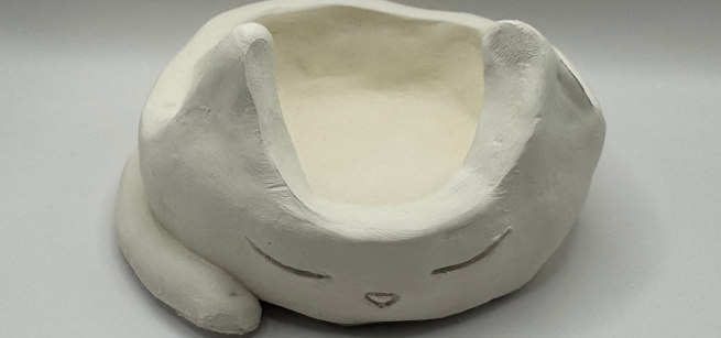 A clay pinch pot in the shape of a cat.