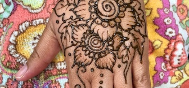 A hand with a henna design by artist Katy DeBra