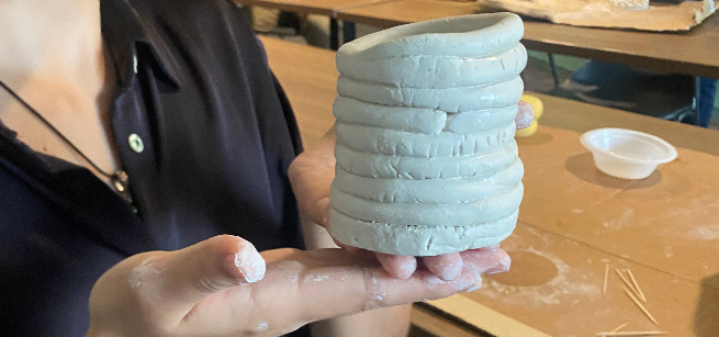 hands holding a clay sculpture